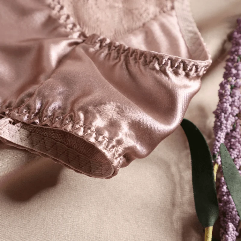 Eleganter, weißer Seidenslip mit französischem Spitzenrand und floralem Muster für weichen Tragekomfort und femininen Luxus im Alltag.